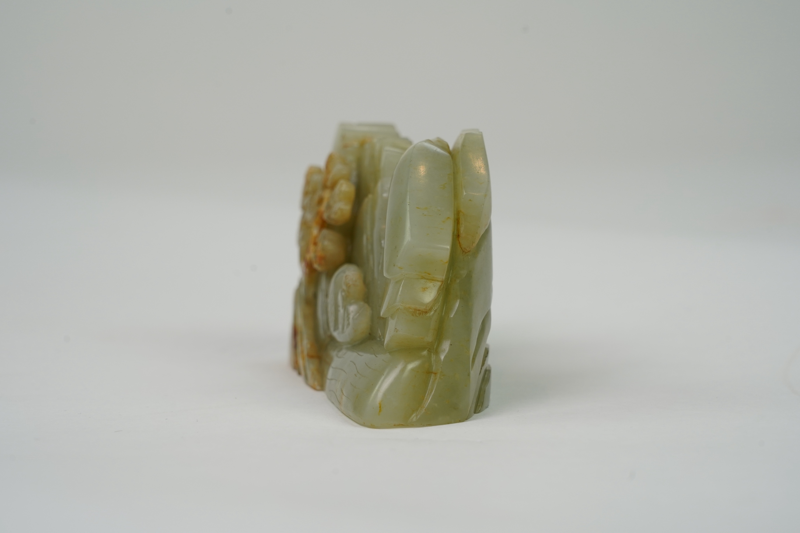 A Chinese celadon and russet jade boulder carving